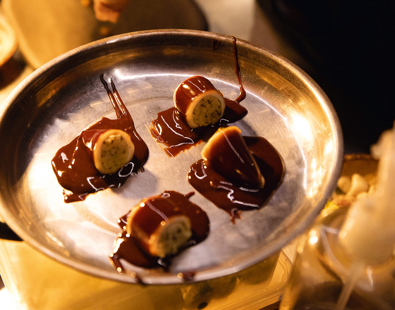A sauce of squid ink and vinegar is poured over Relyenong Pusit, a dish of short grain rice, pickled mustasa, tapuey (a rice wine from Ilocos), and squid from Quezon province made by Toyo Eatery