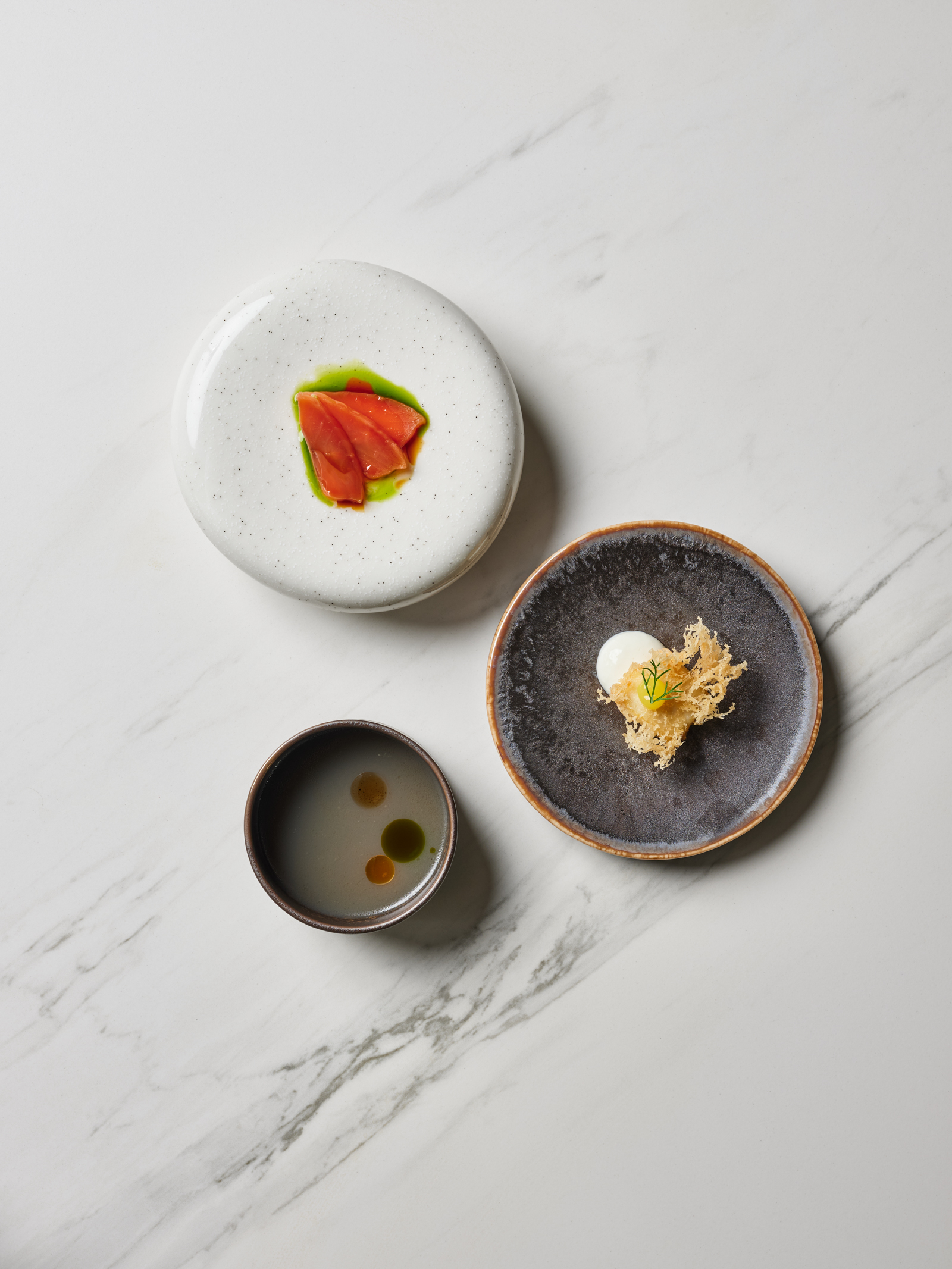 Fjord salmon, juniper, soy, fish and chips, mussel dashi by Josh Boutwood Helm restaurant Ayala Triangle Gardens