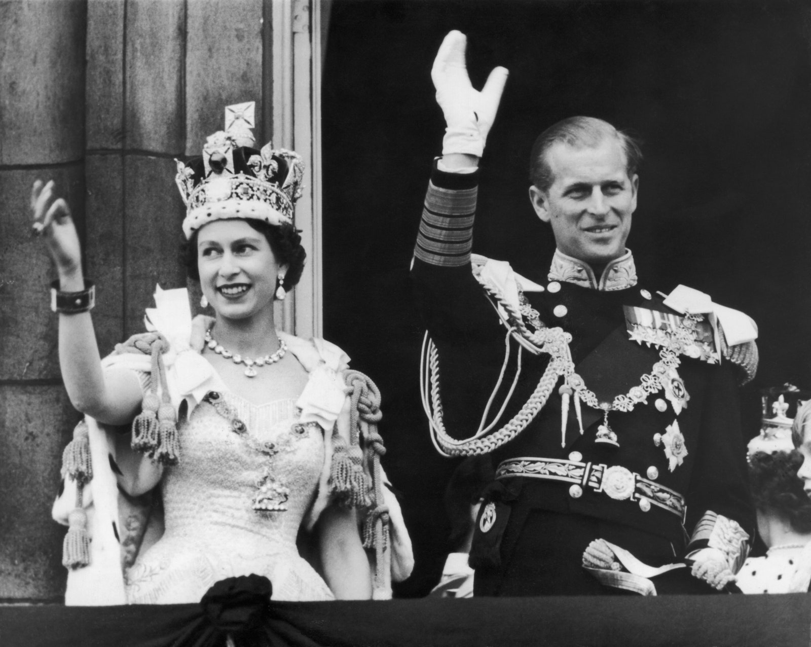 Queen Elizabeth II and the Duke of Edinburgh wave at the crowds from the balcony at Buckingham Palace following Elizabeth’s coronation, June 2, 1953.