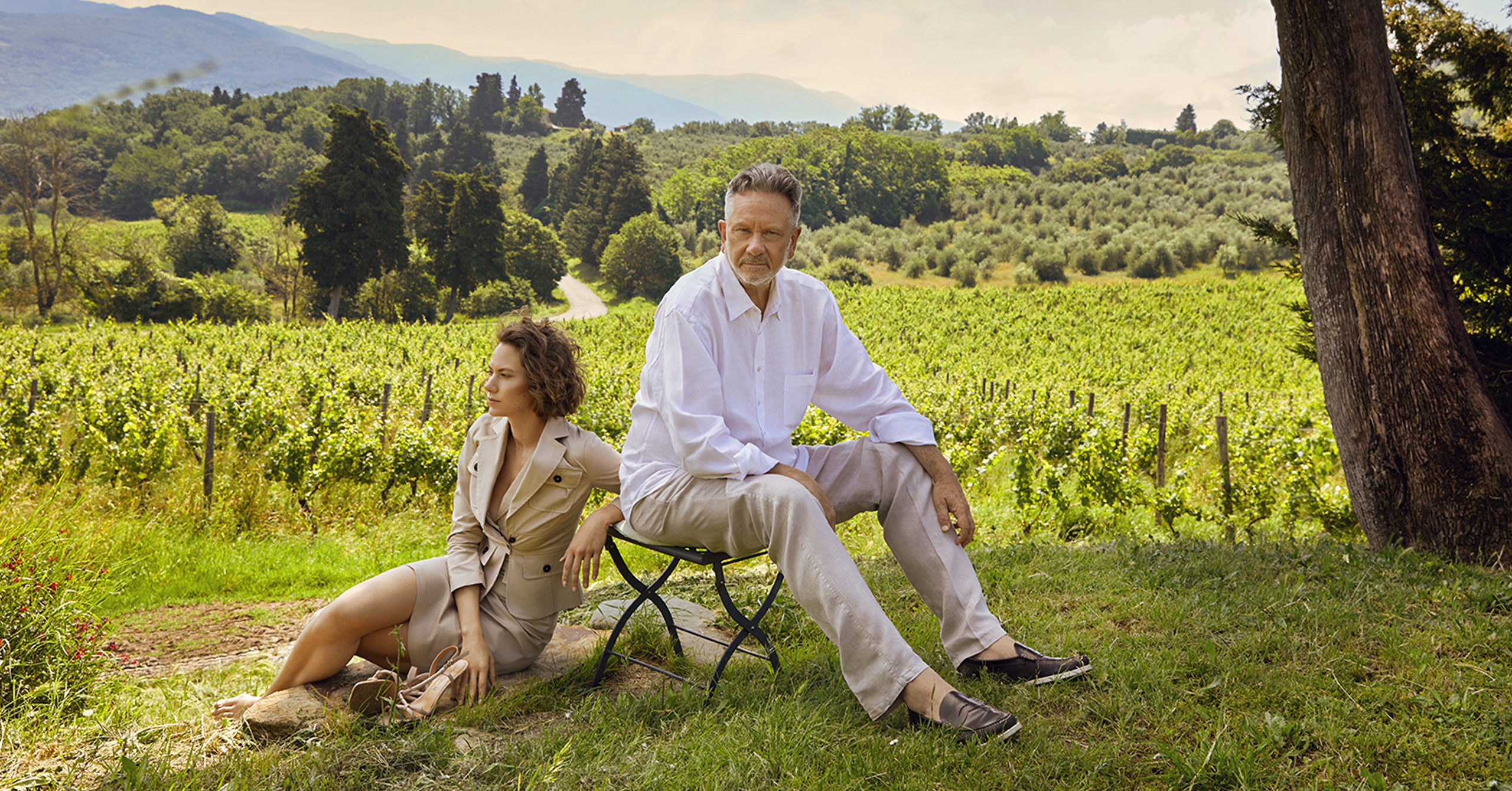 Sean and Emma Ferrer sitting by a tree