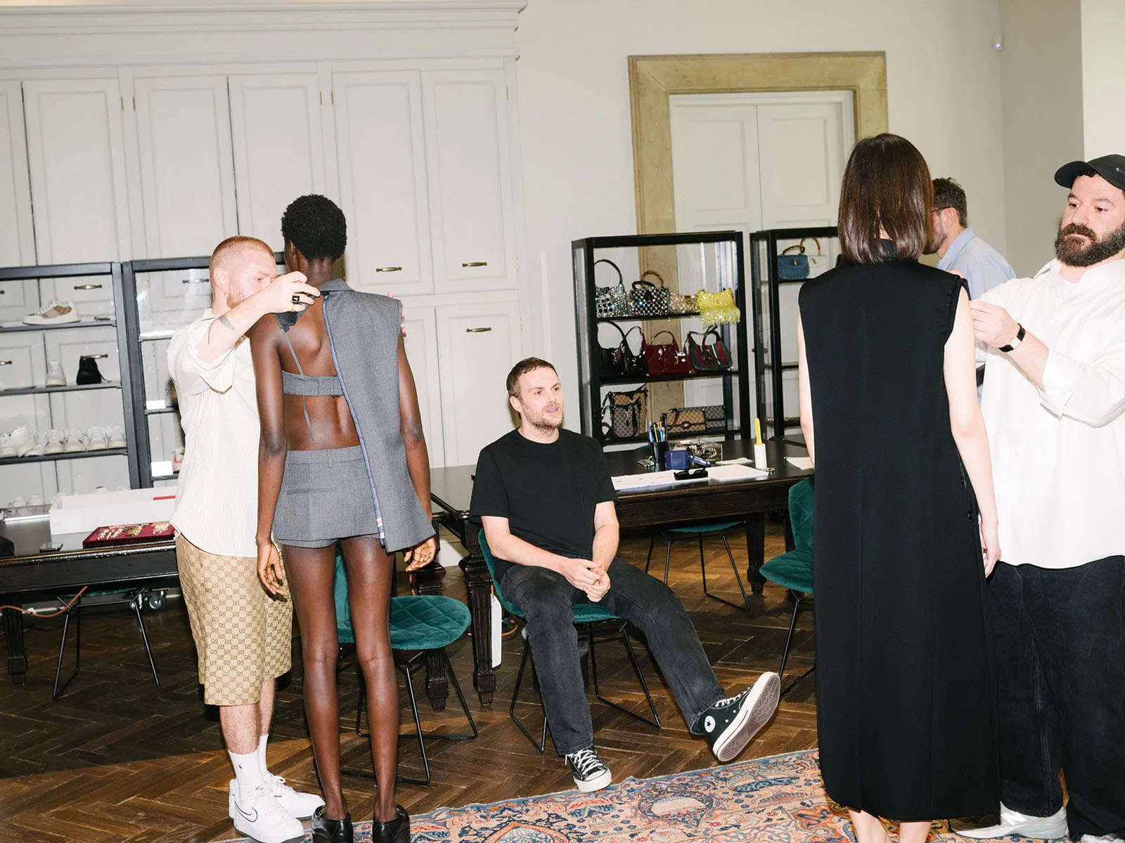 De Sarno, surrounded by his team and models wearing looks-in-progress.