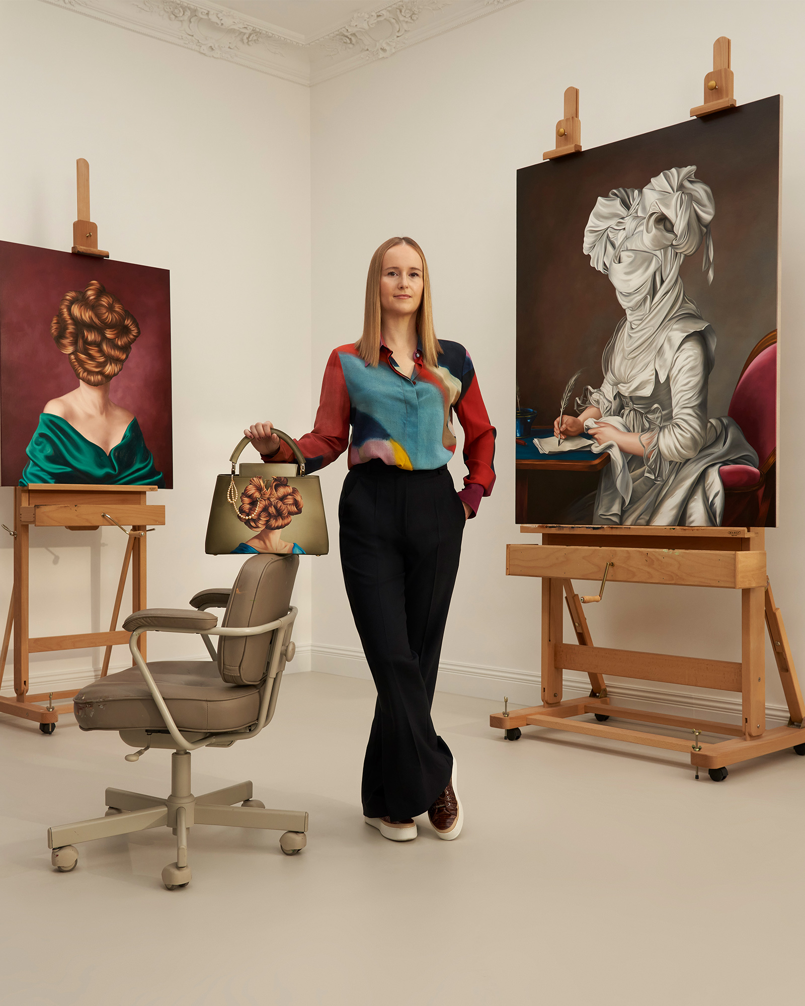 Artist Ewa Juskiewicz posing with her Artycapucines and portrait paintings.