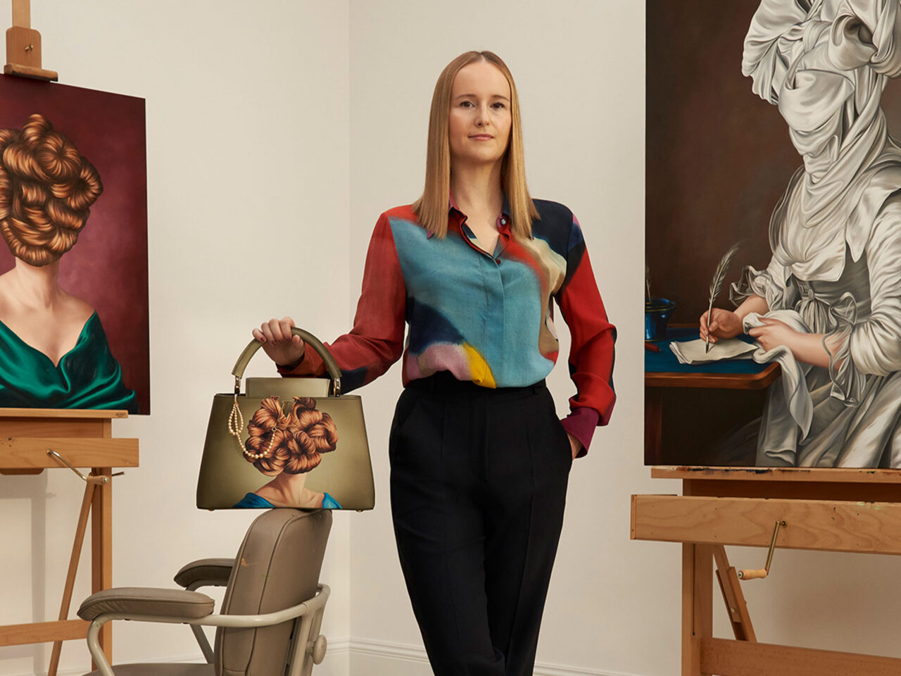 Artist Ewa Juskiewicz posing with her Artycapucines and portrait paintings.