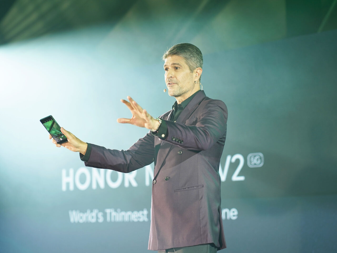 Host James Deakin wearing a plum suit to match the color of the HONOR Magic V2