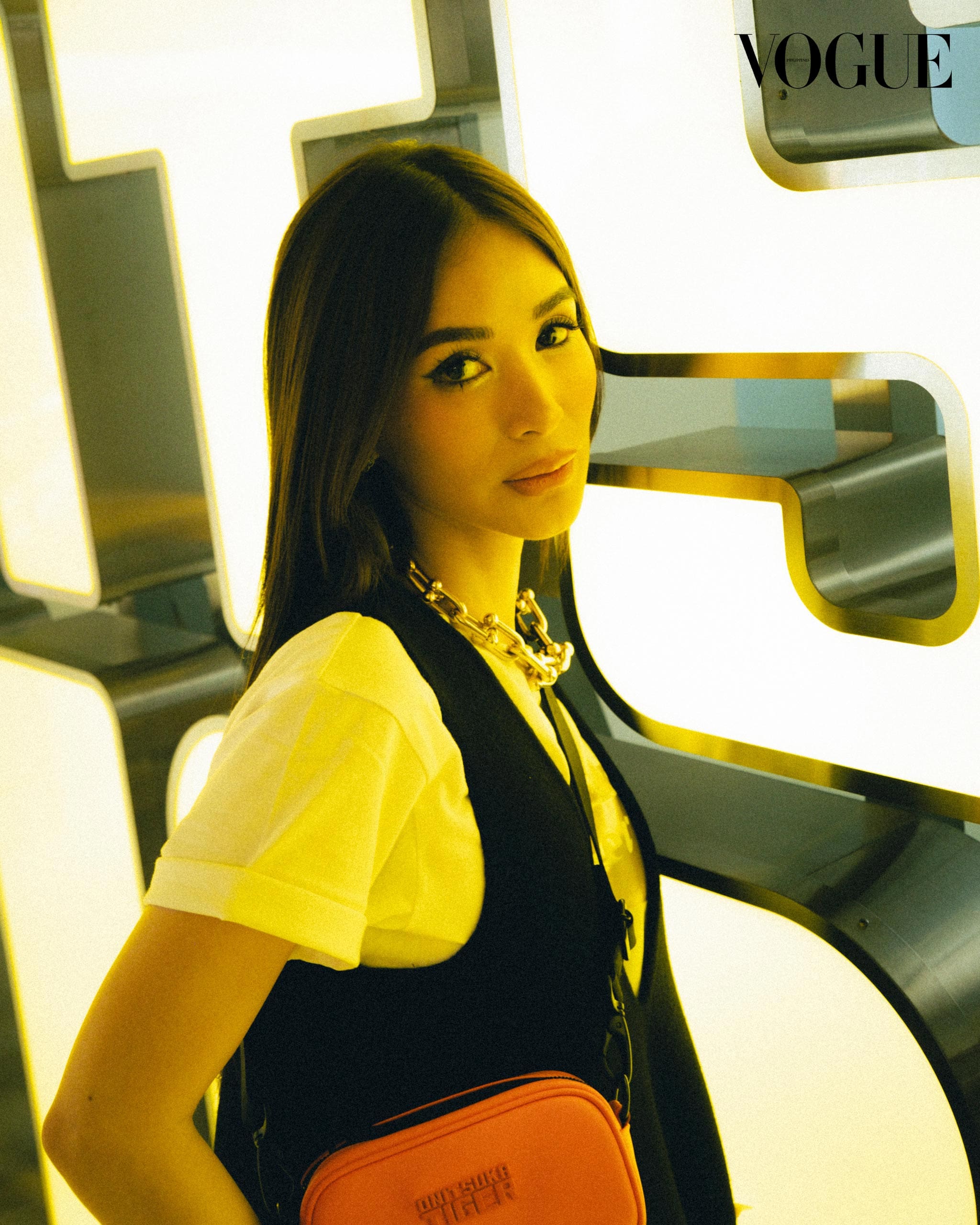 Heart Evangelista strikes a pose for a photo, with a vibrant Onitsuka Tiger sign in the background