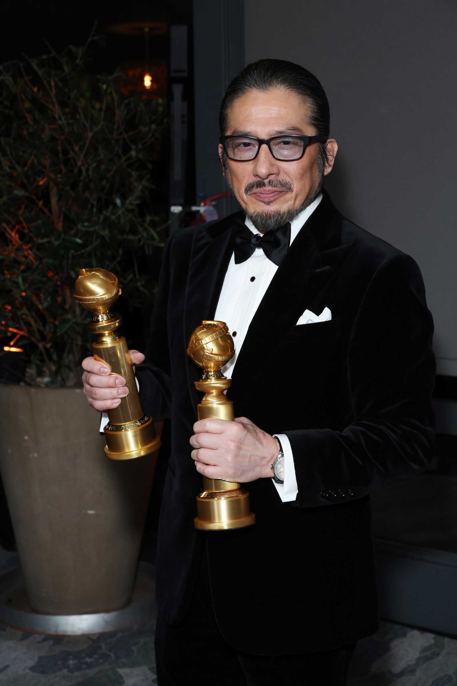 A photo of Hiroyuki Sanada posing with his two Golden Globes trophies.