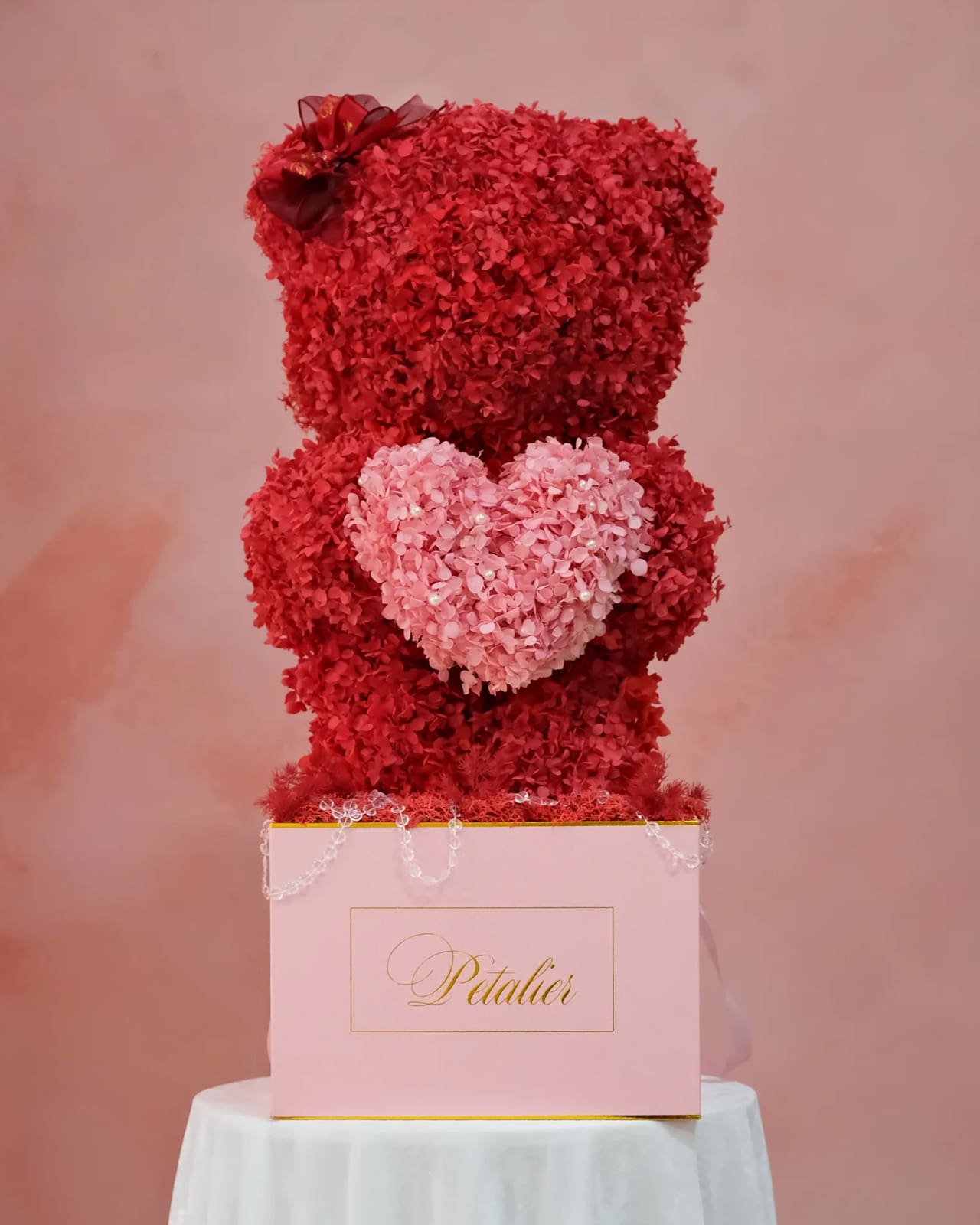A floral teddy bear in red and pink