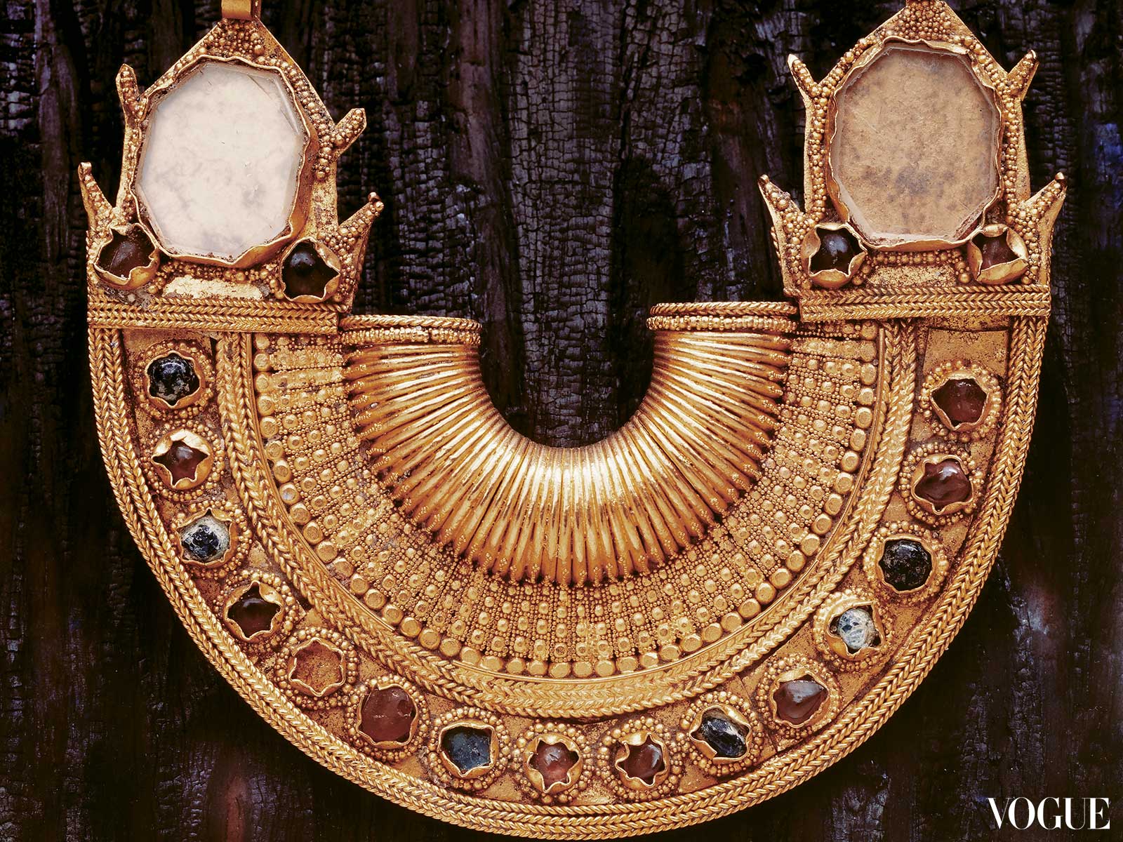 Photograph of a half-moon gold ear ornament, circa 10th to 13th century.