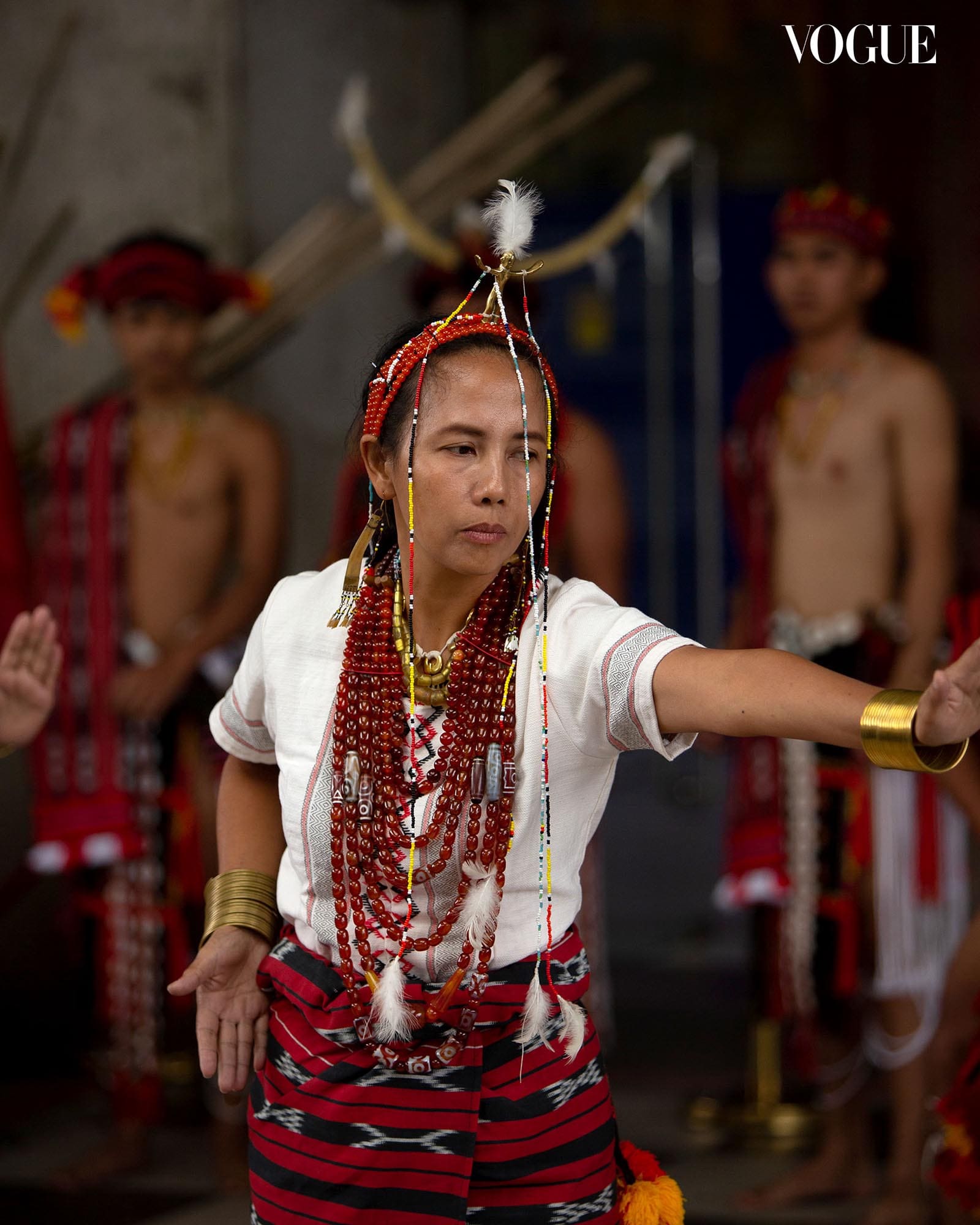 Photo of a woman in traditional woven clothing and beads, performing at WITS.
