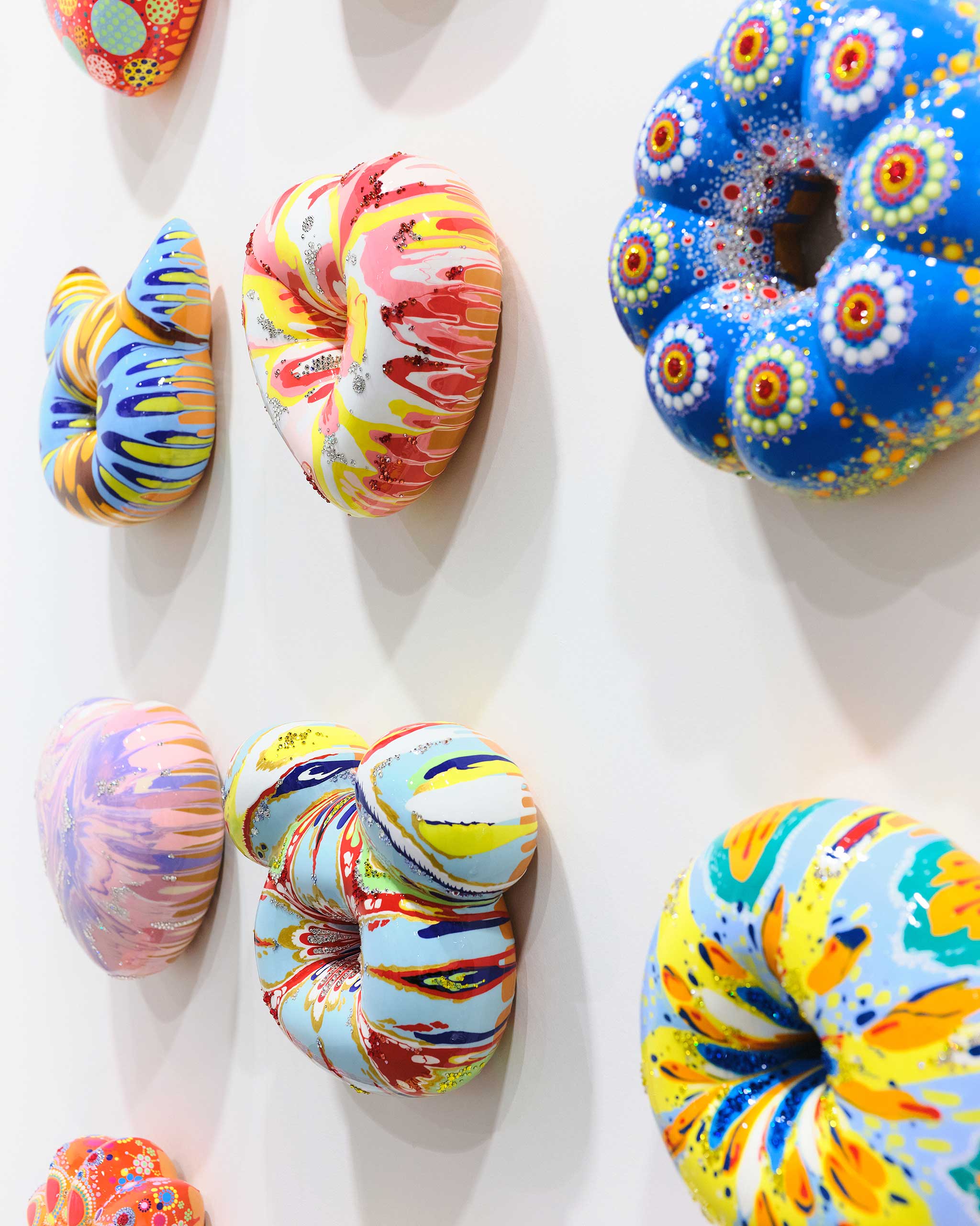 Close up of various shaped donuts on wall.