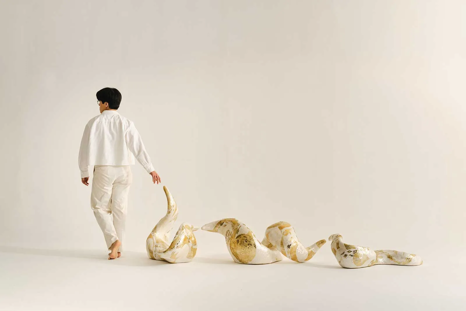 Neil Felipp with his back turned, photographed with his sculpture Constellation 1.0.