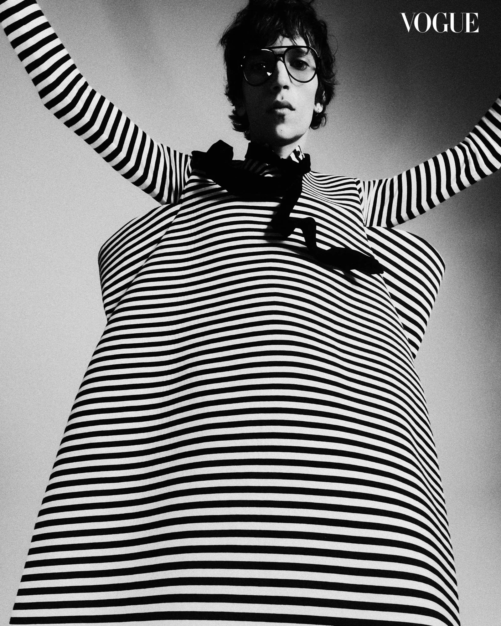 Eliseu wears Tom Ford glasses, Giorgio Armani tie, Loewe dress, and Maison MArgiela socks and shoes