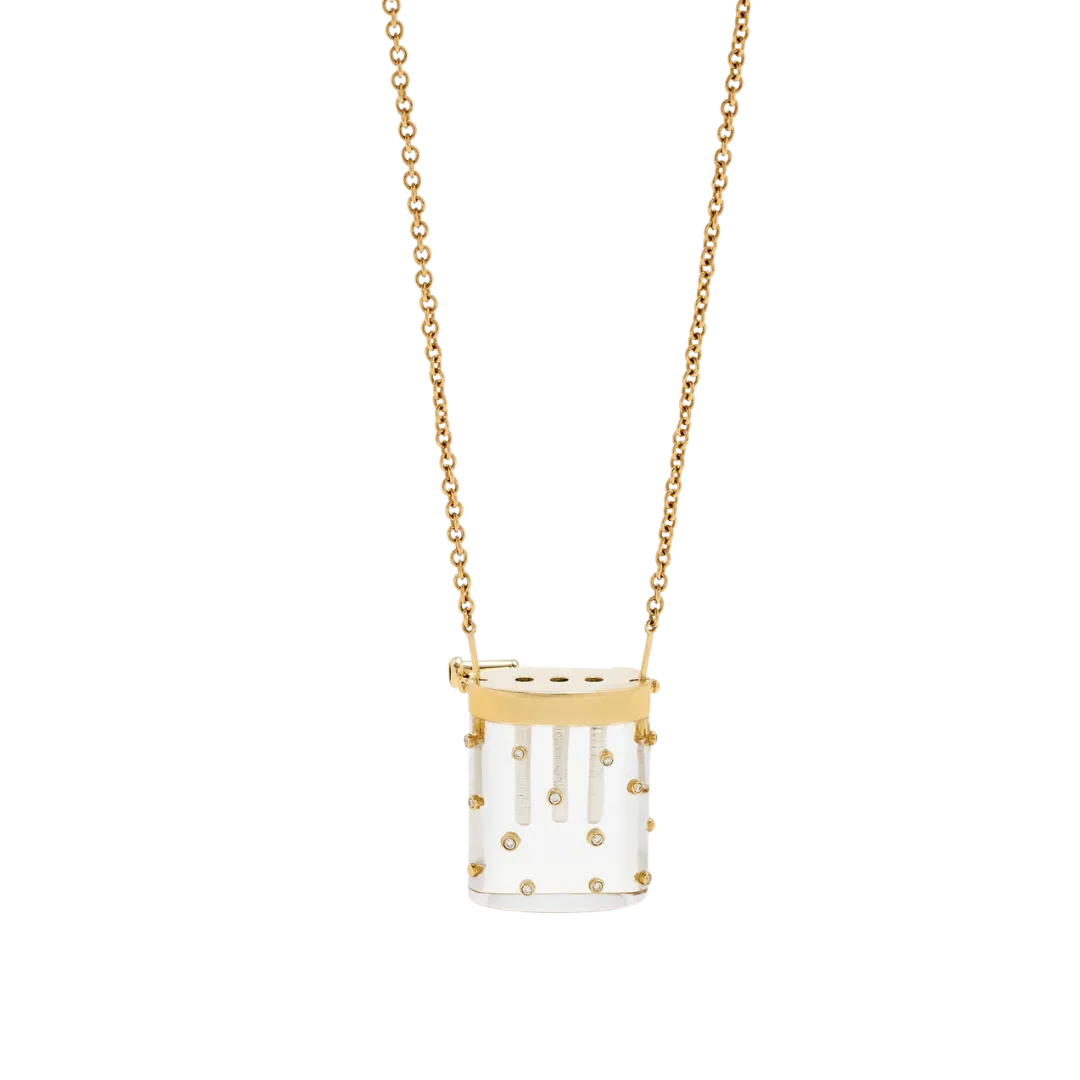 Gold chain necklace with a clear cylindrical pendant featuring gold caps and small decorative studs inside the tube.