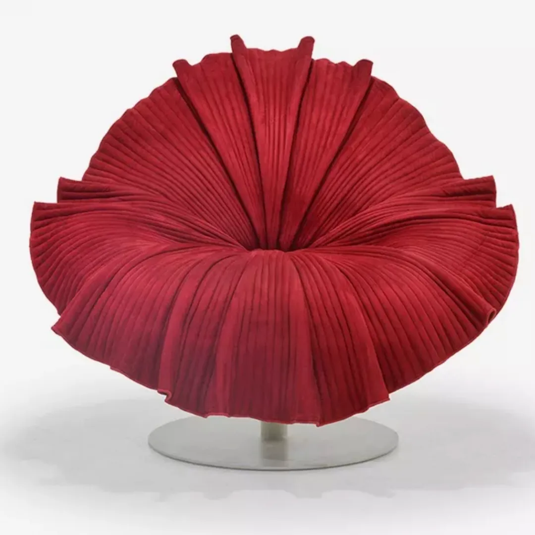 Red pleated circular lounge chair on a metal pedestal, modern sculptural seating piece.