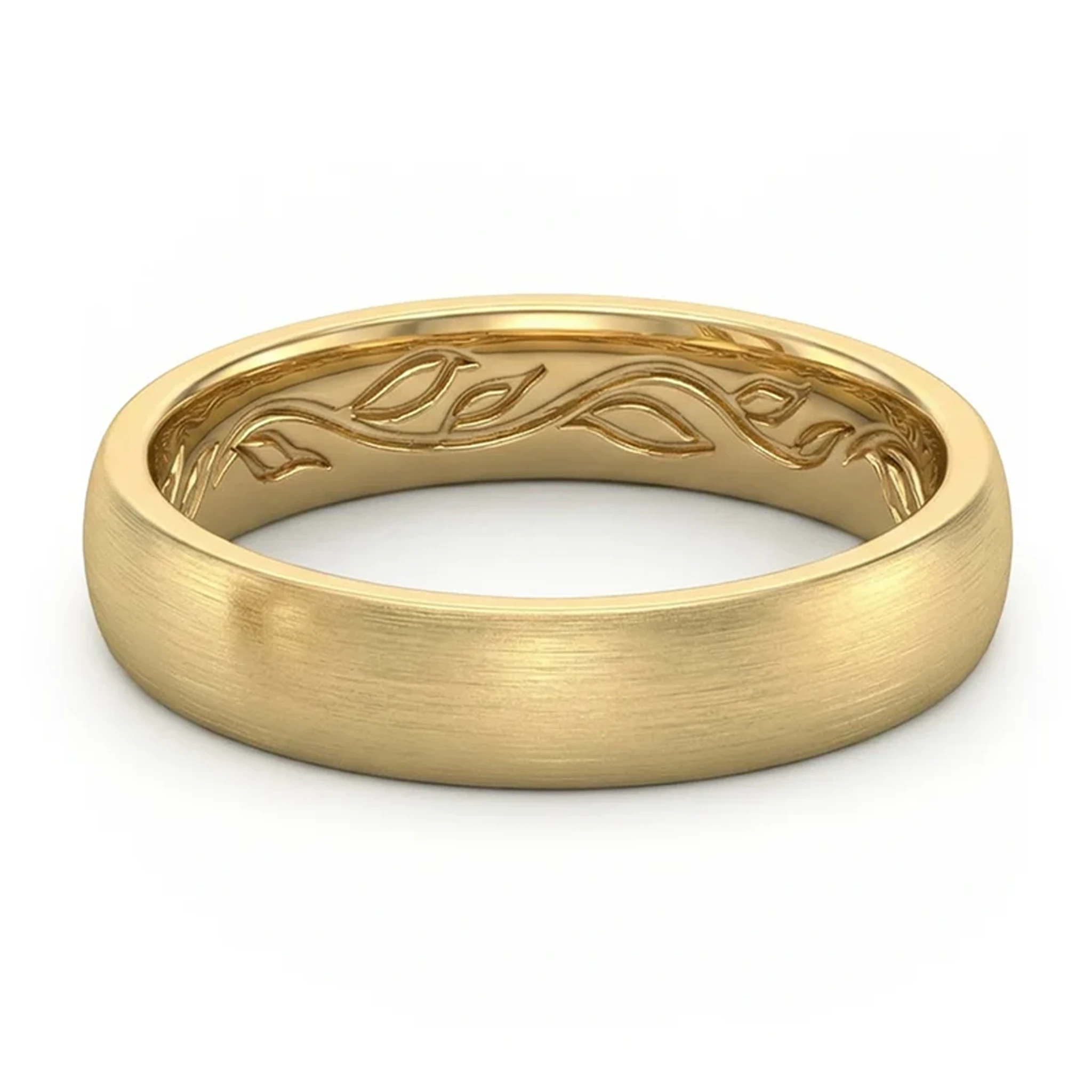 Close-up of a gold wedding band with intricate vine engraving along the inner edge on a white background.