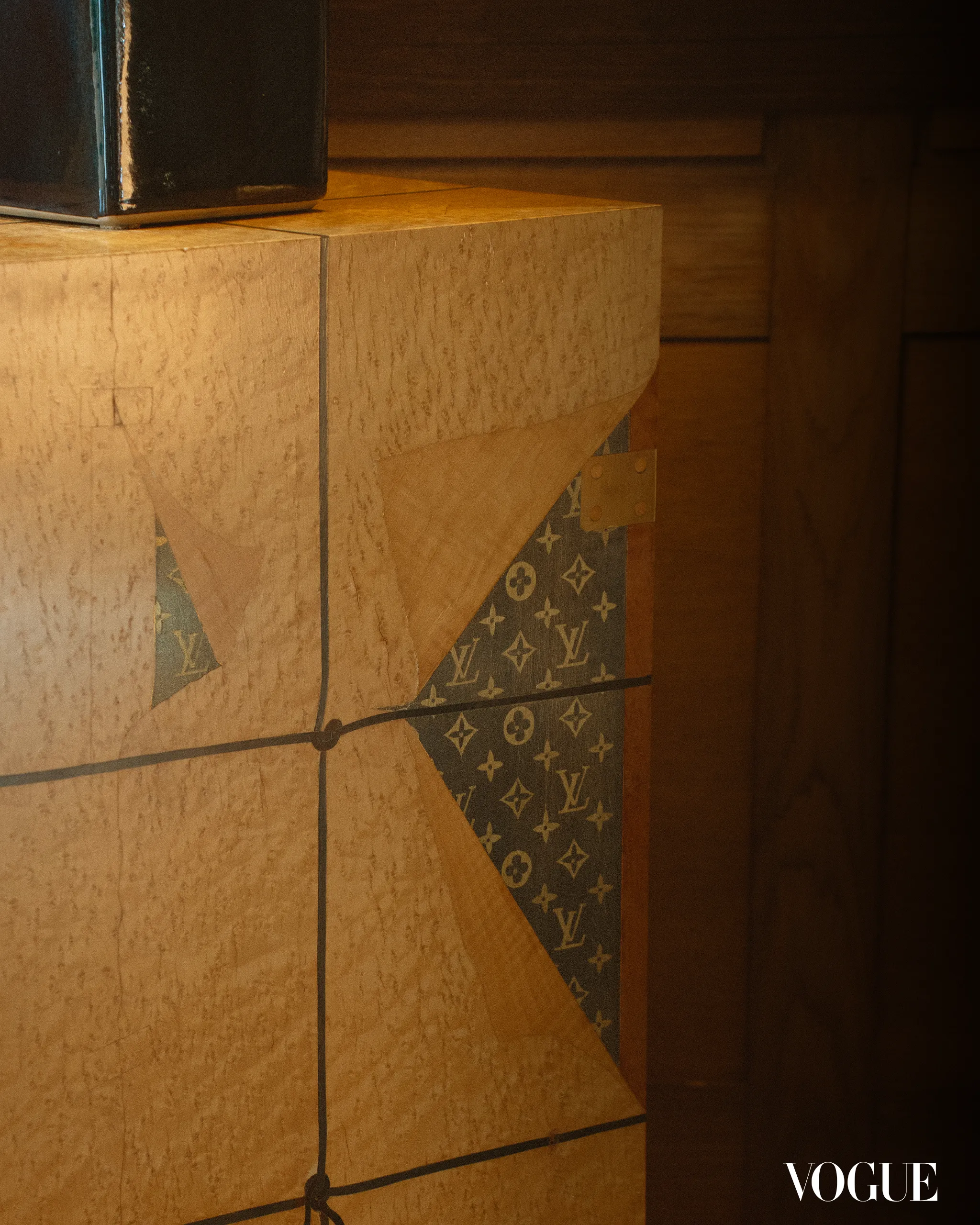 Stone column wrapped in LV monogram paper against a dark backdrop; Vogue logo appears in the bottom-right corner.