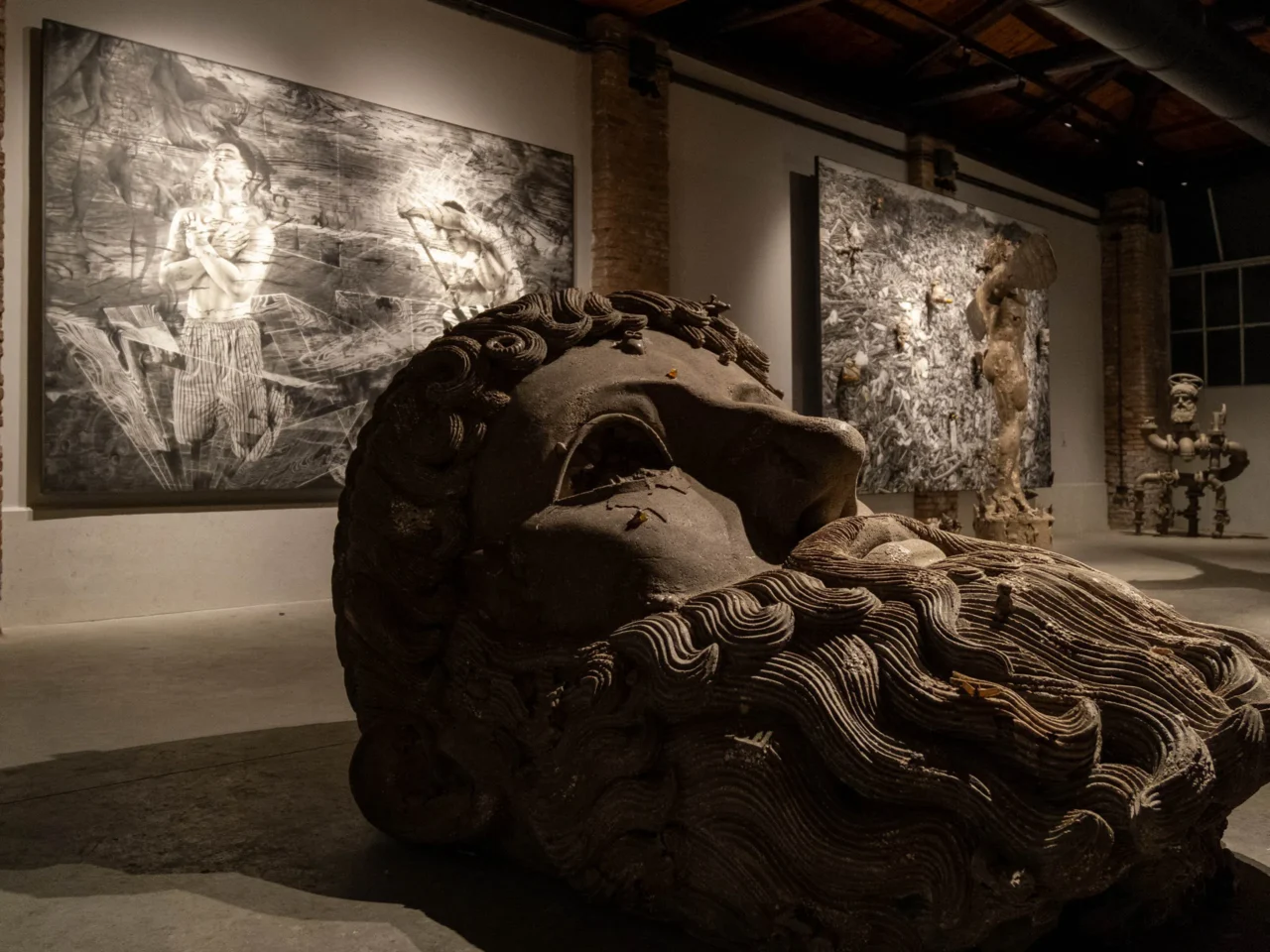 Massive sculpture with rope-like ridges in a dim museum gallery.
