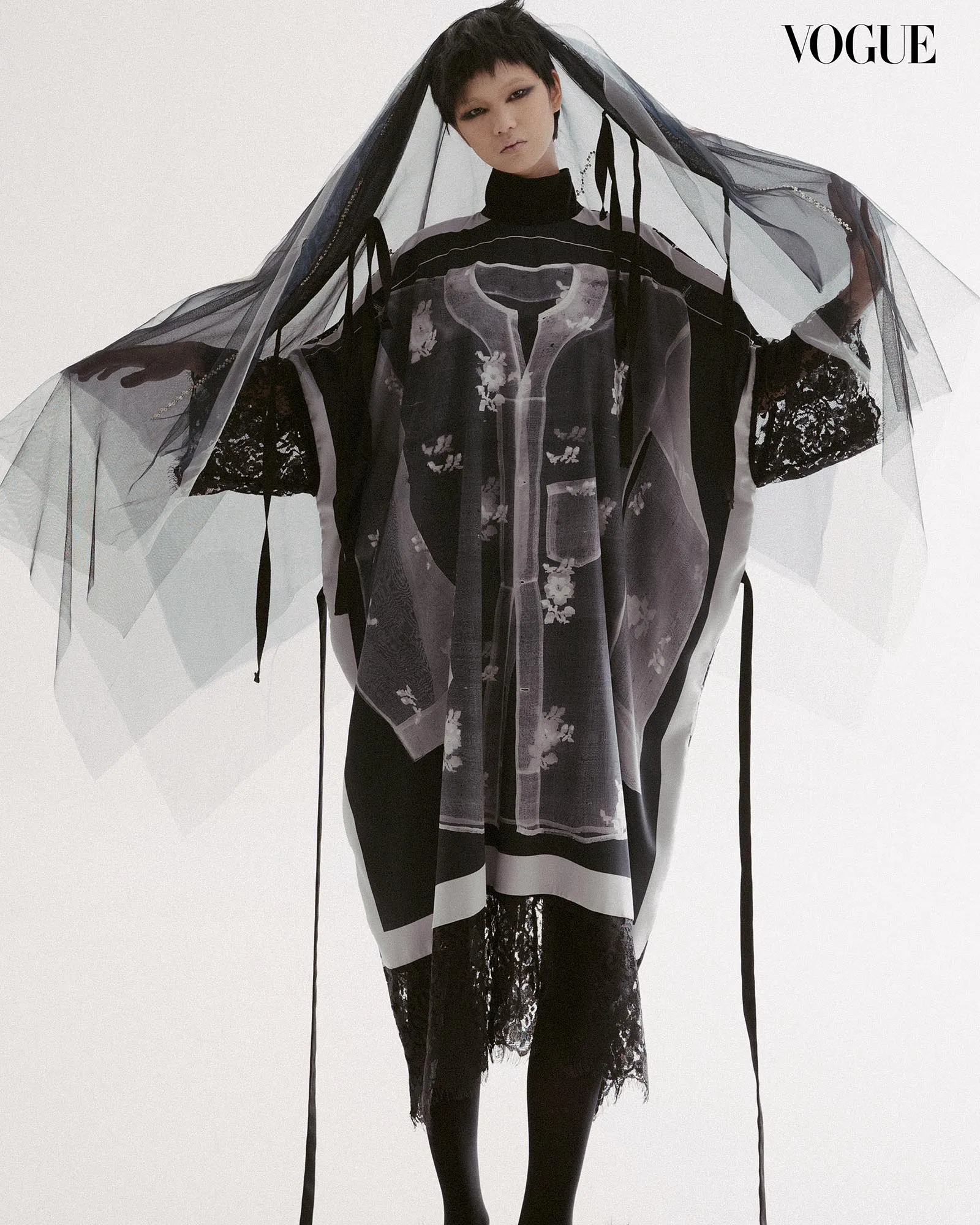 Model in avant-garde sheer layered clothing with lace, a translucent veil over the head; Vogue fashion shoot Ensemble scenario.