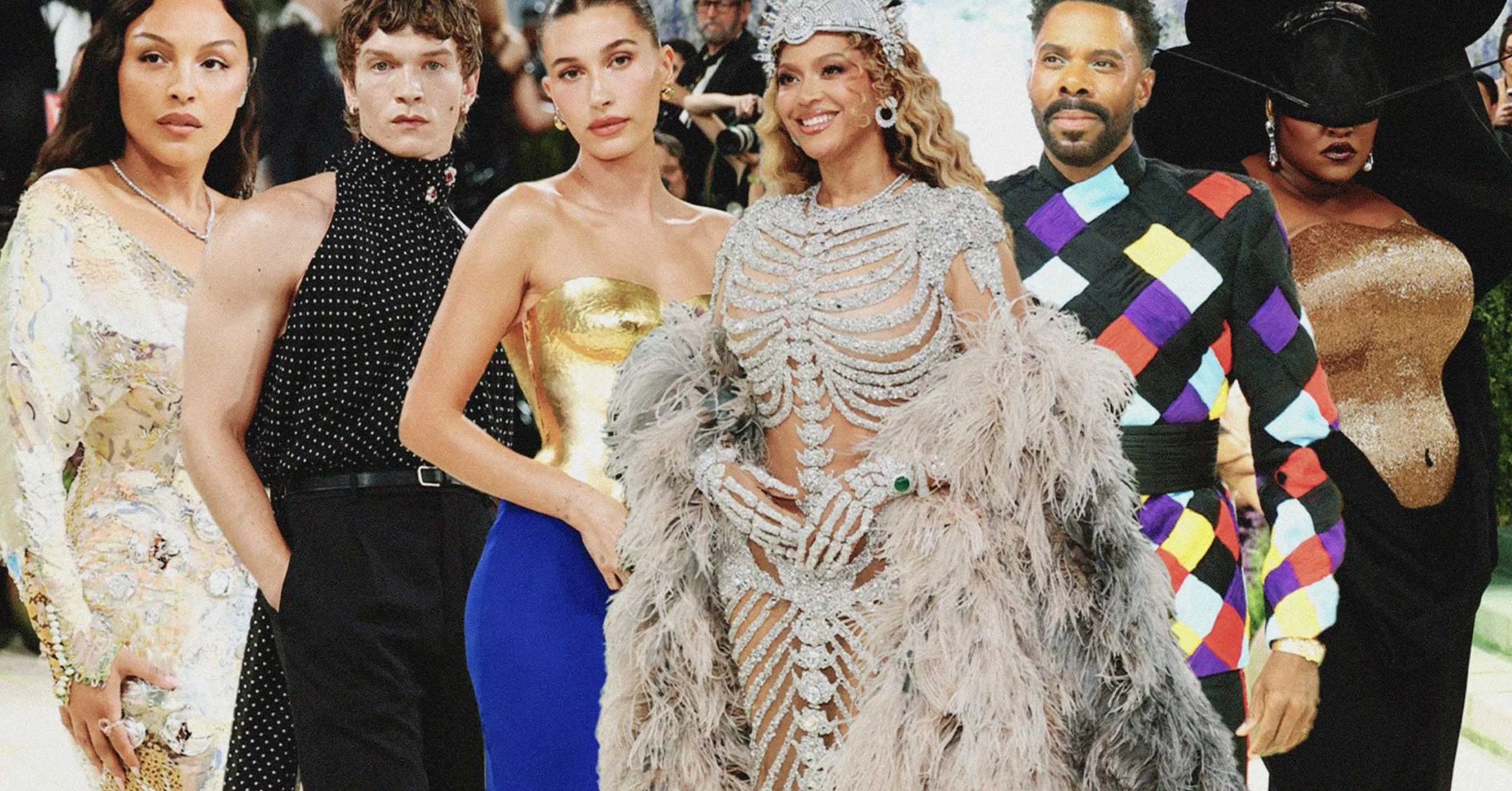 Group of celebrities posing together on a red carpet in glamorous, ornate outfits.