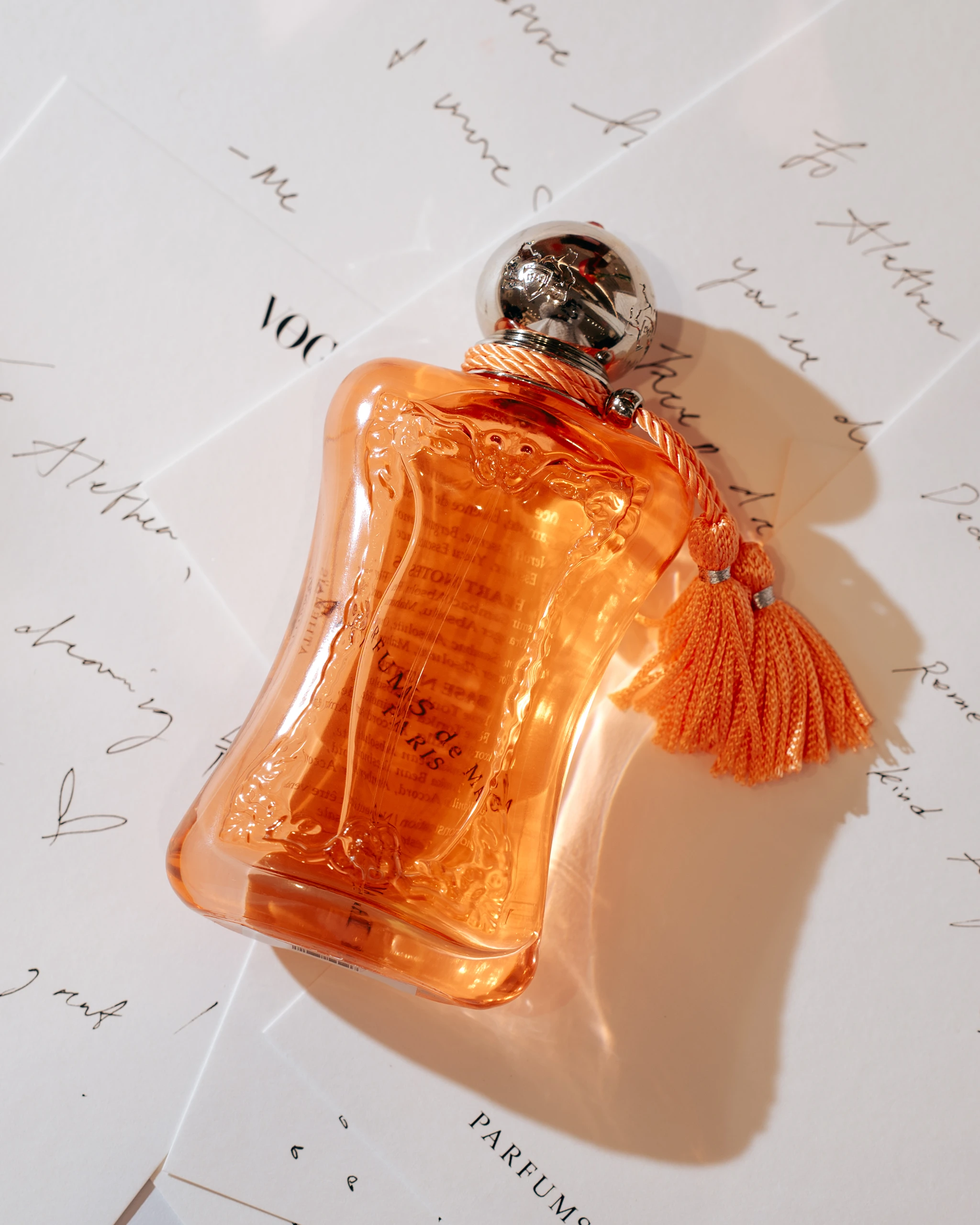 Parfum de Marly Athénaïs Fragrance Bottle on top of notecards written by guests.