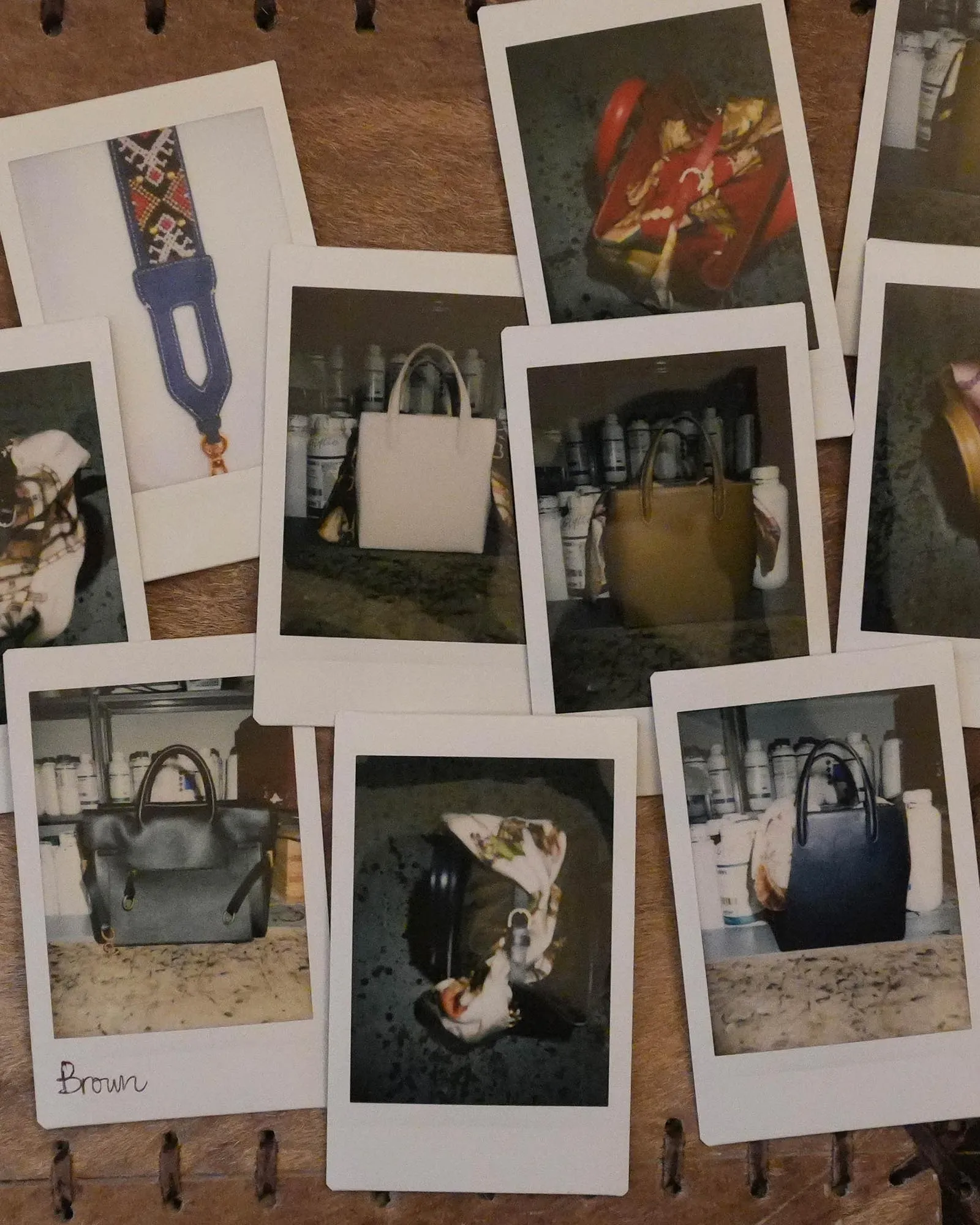 Scattered Polaroid photos on a wooden surface showing bags, bottles, and a belt.