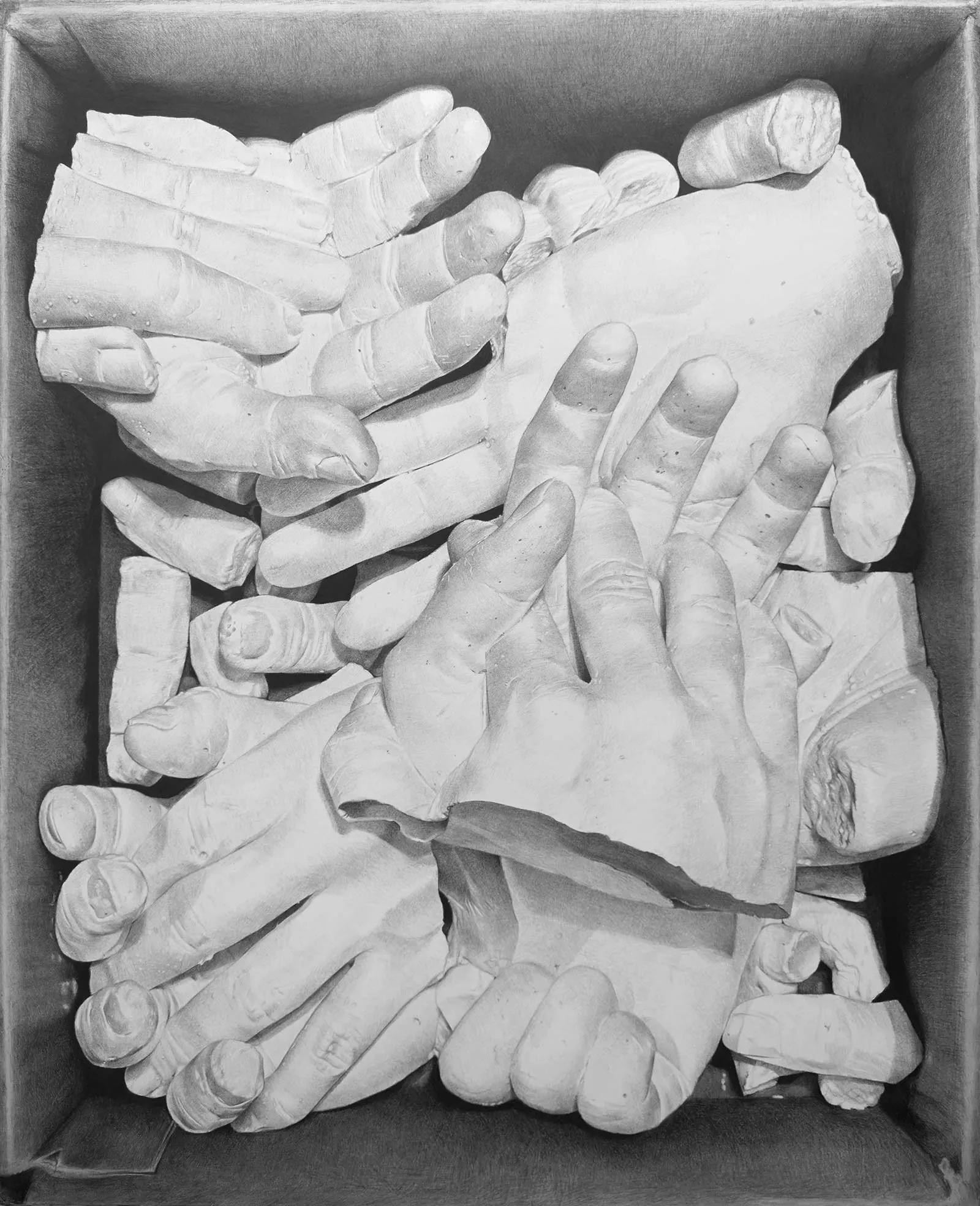 Box filled with white plaster casts of hands overlapping each other in a crate/box vast arrangement of hand molds.