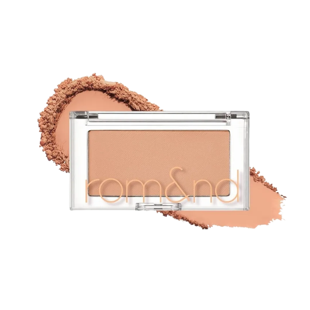 Rom&nd pressed powder compact in peach shade with powder smear behind it.