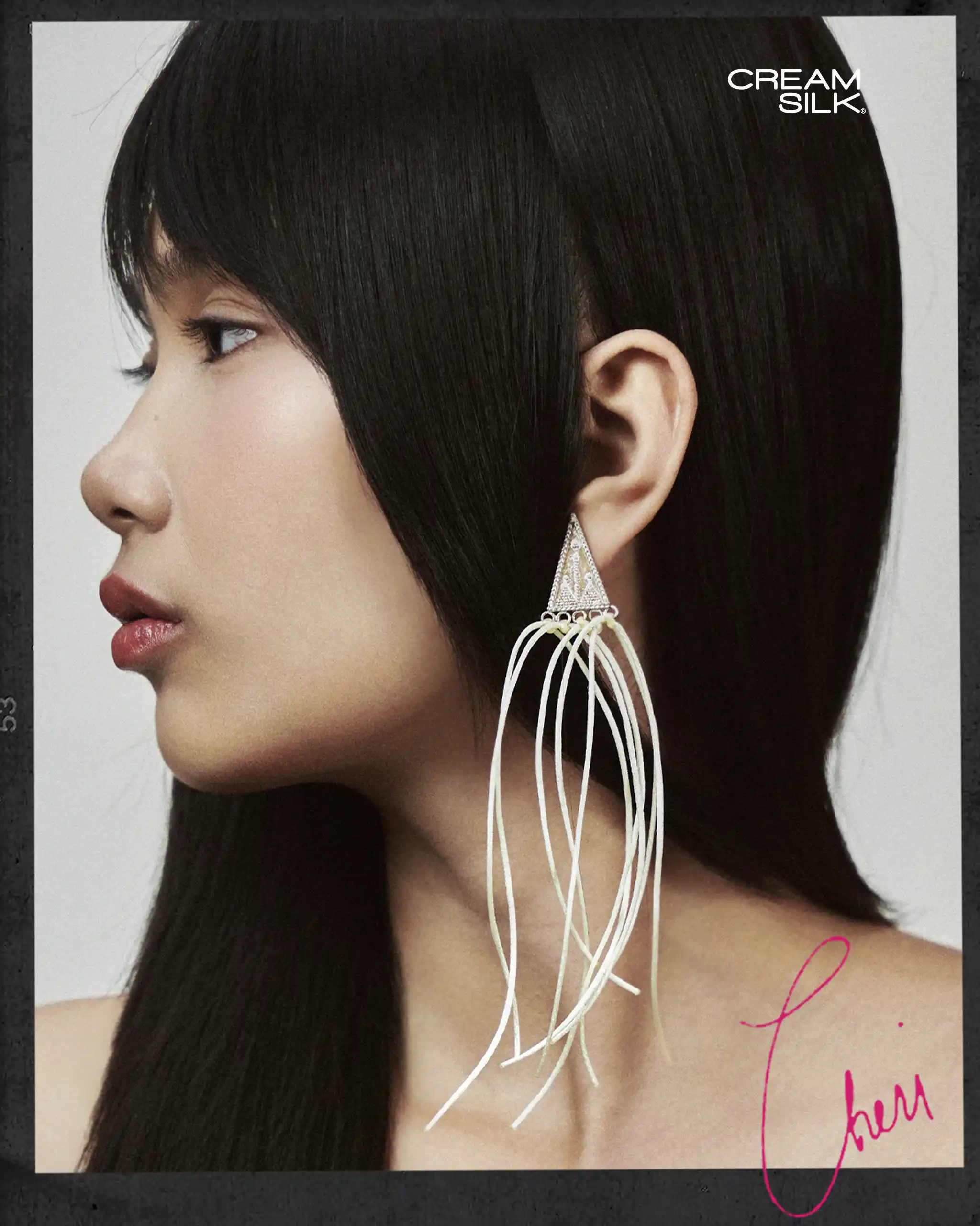 Profile view of a woman with sleek, long black hair wearing a large dangling earring; Cream Silk logo appears in the top-right corner.