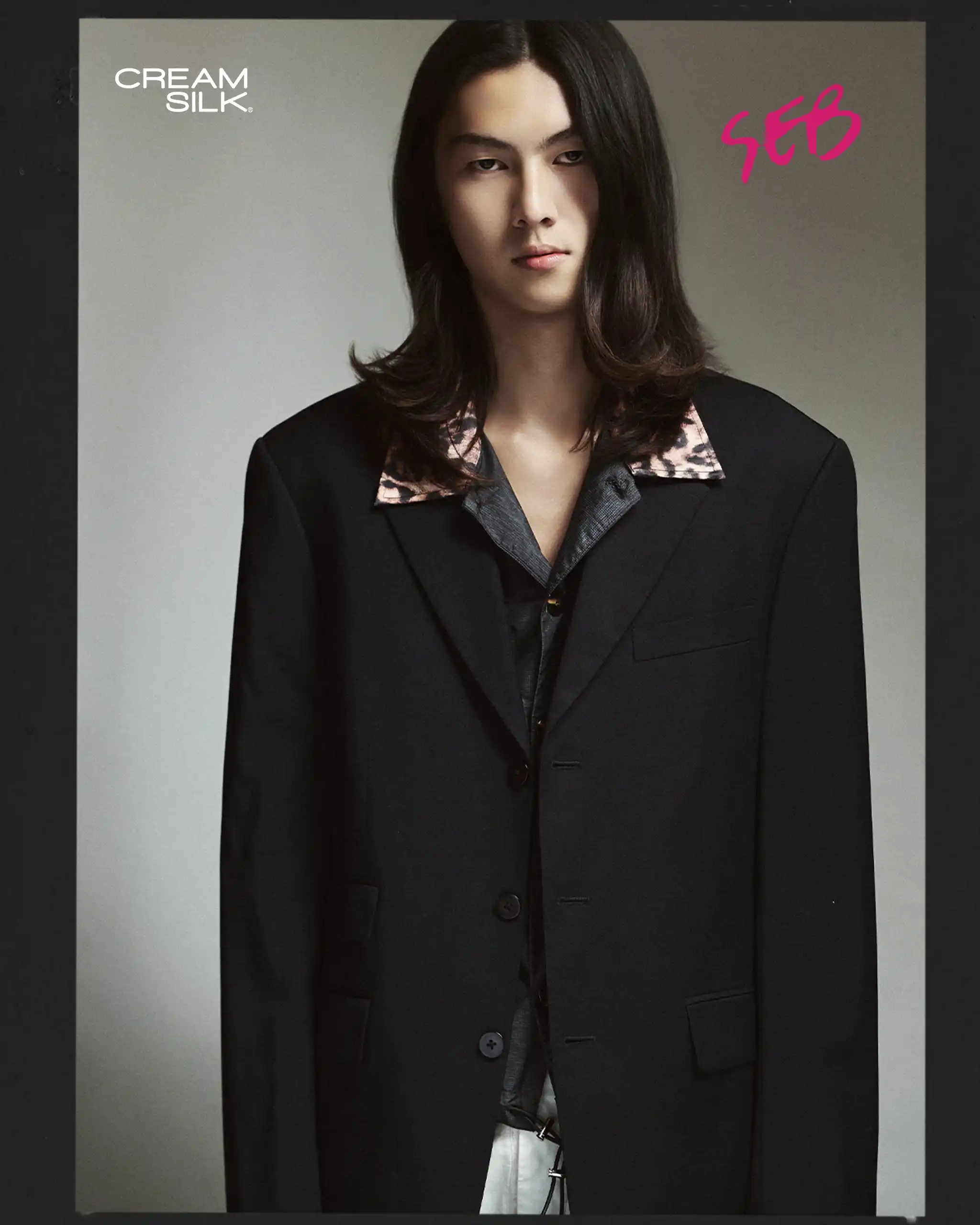 Portrait of a person with long dark hair wearing a black blazer, Cream Silk logo in the upper-left corner and pink handwritten text in the upper-right corner.
