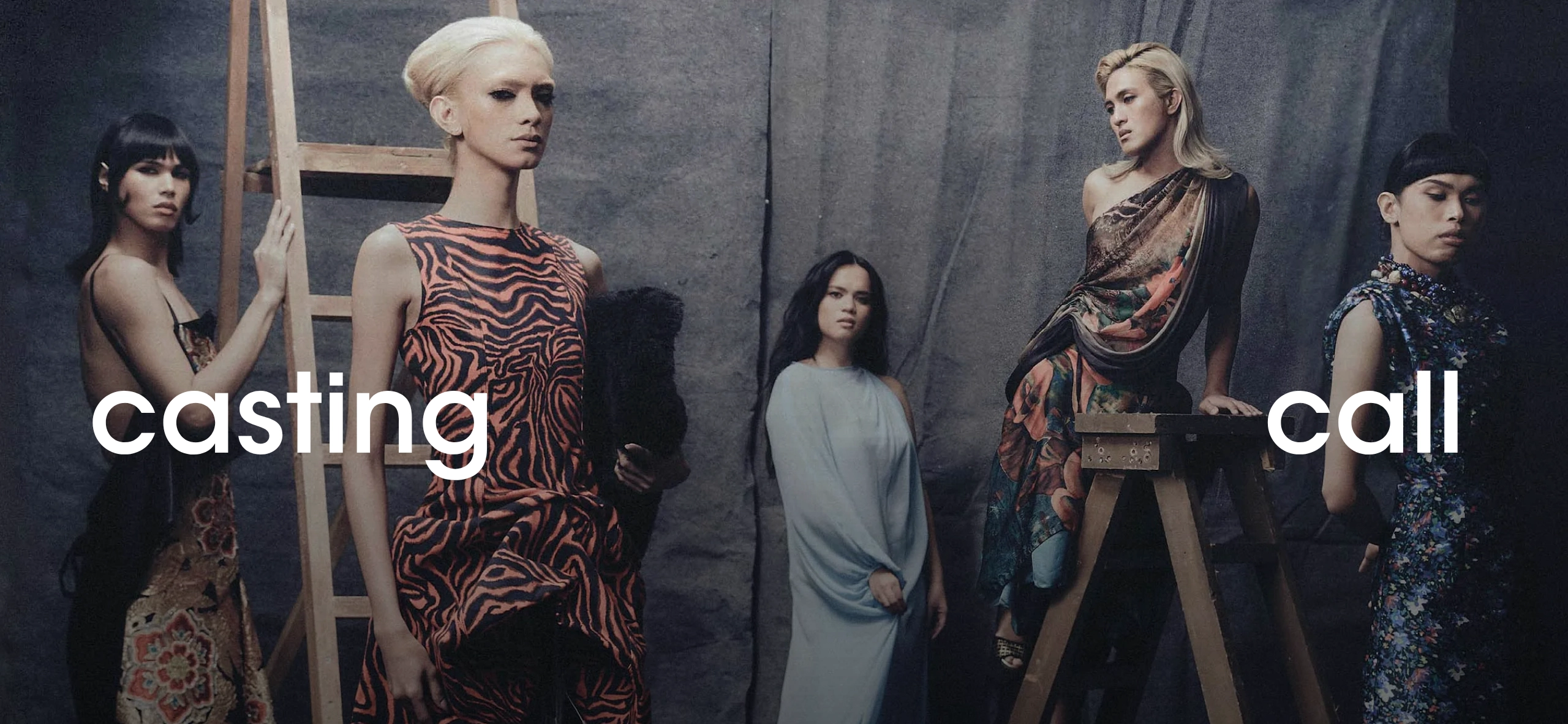 Five models pose in a studio wearing colorful dresses, with large white 'casting call' text across the scene.
