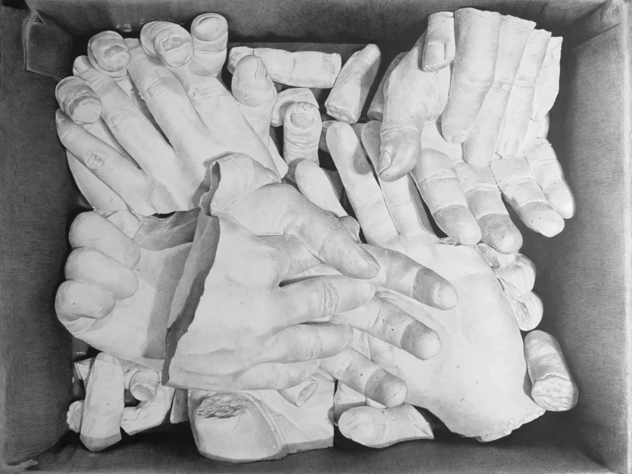 Black-and-white sculpture of multiple hands interlaced together, viewed from above.