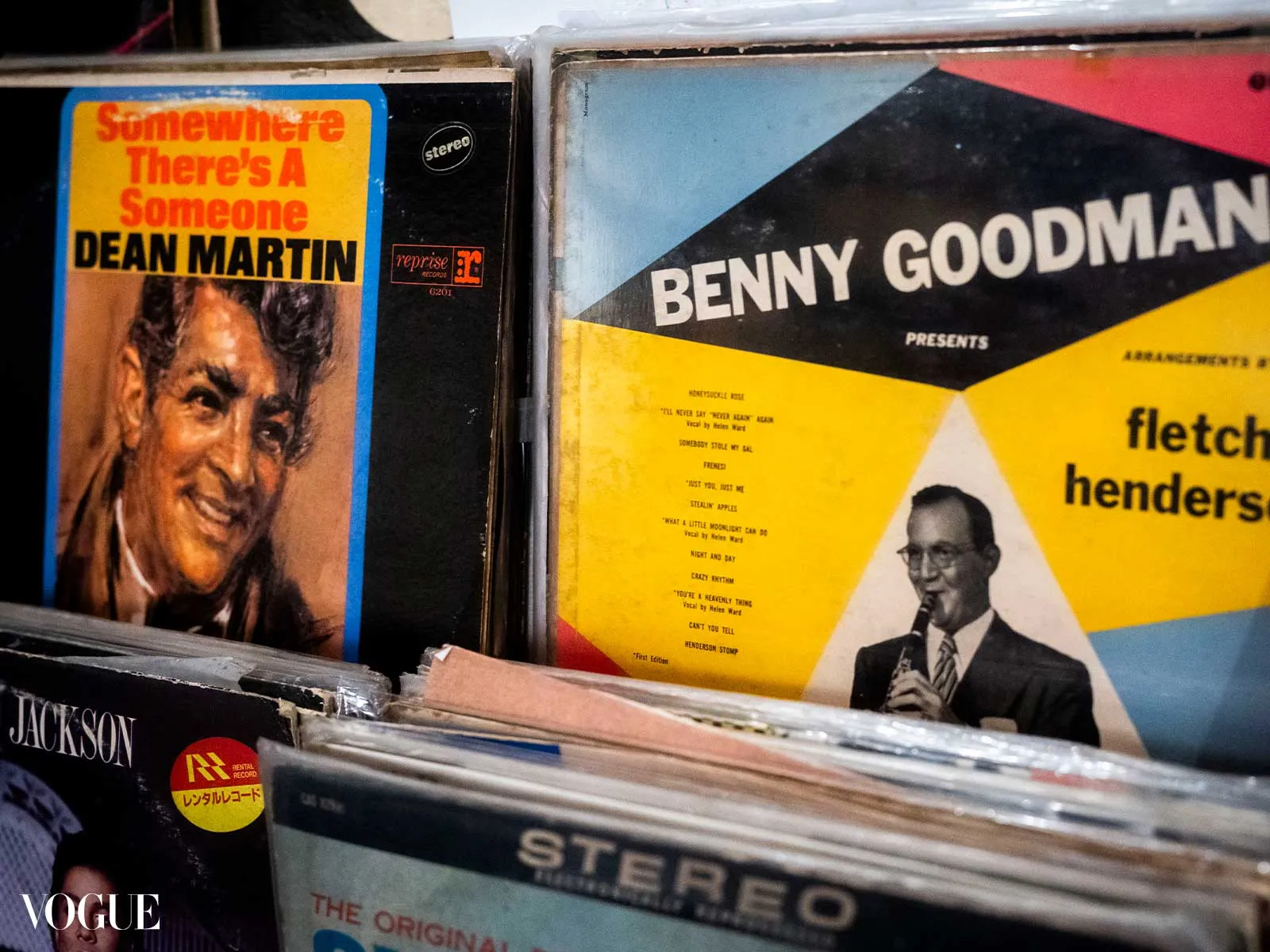 Close-up of colorful vintage record covers in a crate, featuring Dean Martin on the left and Benny Goodman on the right.