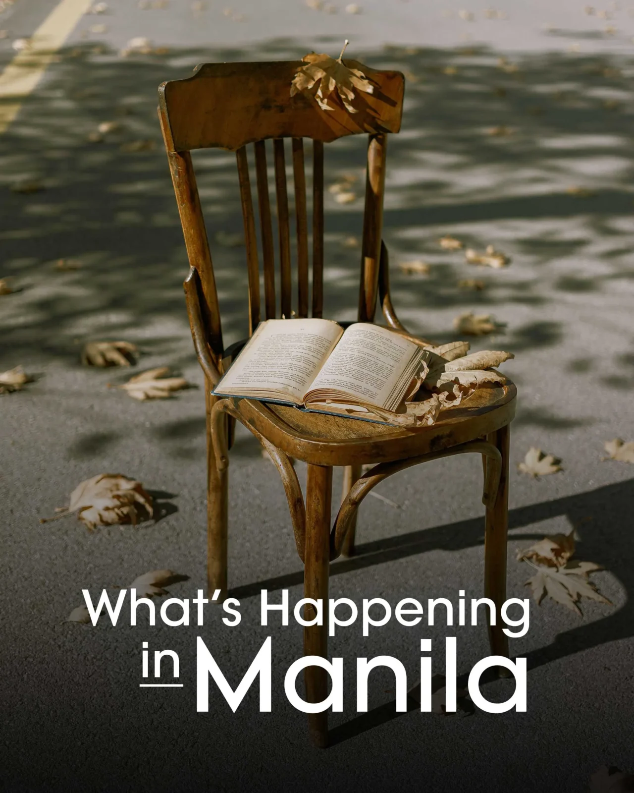 Wooden chair with an open book on the seat on a street, autumn leaves scattered, overlaid with the text “What’s Happening in Manila.”